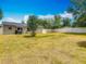Expansive backyard with lush grass, secure fencing, and mature trees under a bright blue sky at 181 Ada Ave, Orange City, FL 32763