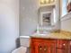 Bathroom with a wood vanity, granite countertop, mirror and toilet at 181 Ada Ave, Orange City, FL 32763
