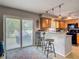 Eat-in kitchen with breakfast bar, wooden cabinets, modern appliances and sliding doors to backyard at 181 Ada Ave, Orange City, FL 32763