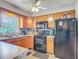 Modern kitchen featuring wooden cabinets, granite countertops, and black appliances at 181 Ada Ave, Orange City, FL 32763