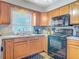 Kitchen area featuring granite countertops, wooden cabinets, and black appliances at 181 Ada Ave, Orange City, FL 32763