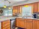 Kitchen with stainless steel dishwasher, granite countertops, and wooden cabinets at 181 Ada Ave, Orange City, FL 32763