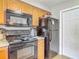 Kitchen with black appliances, light wood cabinets, and light granite countertops at 181 Ada Ave, Orange City, FL 32763