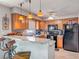 Open kitchen featuring breakfast bar, wood cabinets, granite countertops and modern appliances at 181 Ada Ave, Orange City, FL 32763