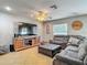 Cozy living room featuring tile floors, a ceiling fan, and a large sectional sofa at 181 Ada Ave, Orange City, FL 32763
