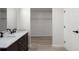 Bathroom featuring a dual vanity, black fixtures, a marble countertop, and a glimpse of a walk-in closet at 1816 Haperon St, Apopka, FL 32703