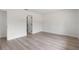 An empty room with wood-look floors and white walls offers a blank canvas with two entry doors at 1816 Haperon St, Apopka, FL 32703