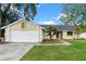 Charming single-story home featuring a red front door, a two-car garage and a well-maintained front yard at 1816 Haperon St, Apopka, FL 32703