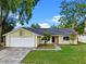 Charming single-story home featuring a red front door, a two-car garage and a well-maintained front yard at 1816 Haperon St, Apopka, FL 32703