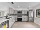 Bright kitchen with stainless steel appliances, gray cabinets, and a tile backsplash over white quartz countertops at 1816 Haperon St, Apopka, FL 32703