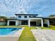 Stunning backyard featuring a modern pool, stone patio, and lush green lawn for outdoor enjoyment at 182 N Phelps Ave, Winter Park, FL 32789