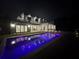 Nighttime view of modern house featuring pool, covered patio, and landscape lighting at 182 N Phelps Ave, Winter Park, FL 32789