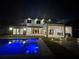 Exterior shot of the backyard at night showing a pool, outdoor kitchen, and patio at 182 N Phelps Ave, Winter Park, FL 32789