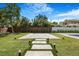 A backyard featuring a manicured lawn, pavers, trees, and perimeter fence for privacy at 182 N Phelps Ave, Winter Park, FL 32789