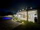 Backyard at night featuring a modern pool, covered outdoor kitchen, and patio lighting at 182 N Phelps Ave, Winter Park, FL 32789