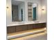 Contemporary bathroom features double sinks, floating vanity with underlighting, and stylish sconces and mirrors at 182 N Phelps Ave, Winter Park, FL 32789