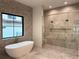 Luxurious bathroom featuring a soaking tub, dual shower heads, marble walls, and gold fixtures at 182 N Phelps Ave, Winter Park, FL 32789