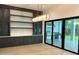 Bright dining area with modern lighting, custom built-ins, and access to the outdoor kitchen through sliding glass doors at 182 N Phelps Ave, Winter Park, FL 32789