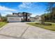 Two-story home with three-car garage, modern architectural design, landscaped front yard, and paver driveway at 182 N Phelps Ave, Winter Park, FL 32789