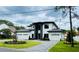 An architecturally pleasing modern home with a three-car garage, landscaped yard and geometric paver driveway at 182 N Phelps Ave, Winter Park, FL 32789