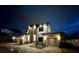 Night shot of a well-lit home exterior with a three-car garage and paved driveway at 182 N Phelps Ave, Winter Park, FL 32789
