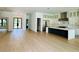 Open-concept kitchen with a large black island, stainless steel appliances, and hardwood floors create a chef's dream at 182 N Phelps Ave, Winter Park, FL 32789