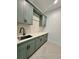 Laundry area with sage green cabinets, white quartz countertop, modern fixtures and stylish backsplash at 182 N Phelps Ave, Winter Park, FL 32789