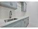 Functional laundry room with light blue cabinets and sleek countertops at 182 N Phelps Ave, Winter Park, FL 32789