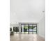 Bright open-concept living room with walls of sliding glass doors that open to a landscaped back yard at 182 N Phelps Ave, Winter Park, FL 32789