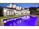 Backyard pool at dusk with outdoor kitchen and travertine pavers at 182 N Phelps Ave, Winter Park, FL 32789