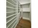 Bright walk-in closet featuring custom shelving, drawers, and hardwood flooring for organized storage at 182 N Phelps Ave, Winter Park, FL 32789