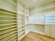 Bright walk-in closet with open shelving, integrated drawers, gold hardware, and hardwood flooring at 182 N Phelps Ave, Winter Park, FL 32789