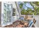 Charming balcony with scenic views of the surrounding trees with comfortable seating for relaxing outdoors at 1901 10Th St, St Cloud, FL 34769