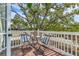 Charming outdoor balcony with seating, a small table, and scenic views of mature trees for relaxation at 1901 10Th St, St Cloud, FL 34769