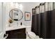 Modern bathroom with a round mirror, sleek vanity, toilet, and a dark shower curtain at 2110 Hillcrest St, Orlando, FL 32803