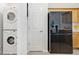 Convenient laundry area with a stacked washer and dryer, plus a modern black refrigerator at 2110 Hillcrest St, Orlando, FL 32803