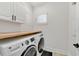 Modern laundry room with new front-load washer and dryer and white cabinets at 2110 Hillcrest St, Orlando, FL 32803