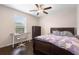 This bedroom features a ceiling fan, wood floors, a large window, and space for a desk or dresser at 2136 J Lawson Blvd, Orlando, FL 32824