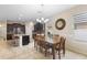 Bright dining area featuring a wooden table, chandelier, and dark cabinetry in the adjacent kitchen at 2136 J Lawson Blvd, Orlando, FL 32824