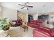Cozy living room with comfortable red sofas, a ceiling fan, and easy access to the kitchen and staircase at 2136 J Lawson Blvd, Orlando, FL 32824