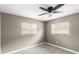 Bright bedroom features two windows, wood-look tile flooring, and a ceiling fan at 2312 Ne 32Nd Pl, Ocala, FL 34479