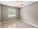 Cozy bedroom features wood-look tile flooring, and a window letting in natural light at 2312 Ne 32Nd Pl, Ocala, FL 34479