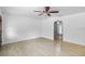 Bright living room featuring wood-look tile floors, neutral paint, a ceiling fan, and arched doorways at 2312 Ne 32Nd Pl, Ocala, FL 34479