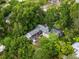 Home with a patio surrounded by dense trees and landscaping at 2312 Vivada St, Orlando, FL 32803