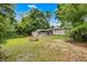 Expansive backyard with a fire pit, lush greenery, and charming exterior views at 2312 Vivada St, Orlando, FL 32803