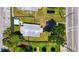 An aerial view of a cozy home with a grey roof, surrounded by lush green grass, and a small blue pool at 233 E Church Ave, Longwood, FL 32750
