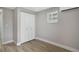 Cozy bedroom featuring laminate flooring, neutral gray walls, and a closet with white folding doors at 233 E Church Ave, Longwood, FL 32750
