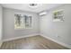 Inviting bedroom featuring modern ceiling fan, two large windows with window shades and light gray walls and vinyl flooring at 233 E Church Ave, Longwood, FL 32750