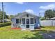 Charming home with a cozy, screened porch entry, landscaped front yard, and a white picket fence at 233 E Church Ave, Longwood, FL 32750