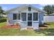 Charming blue home with a welcoming, enclosed front porch and freshly mulched landscaping at 233 E Church Ave, Longwood, FL 32750